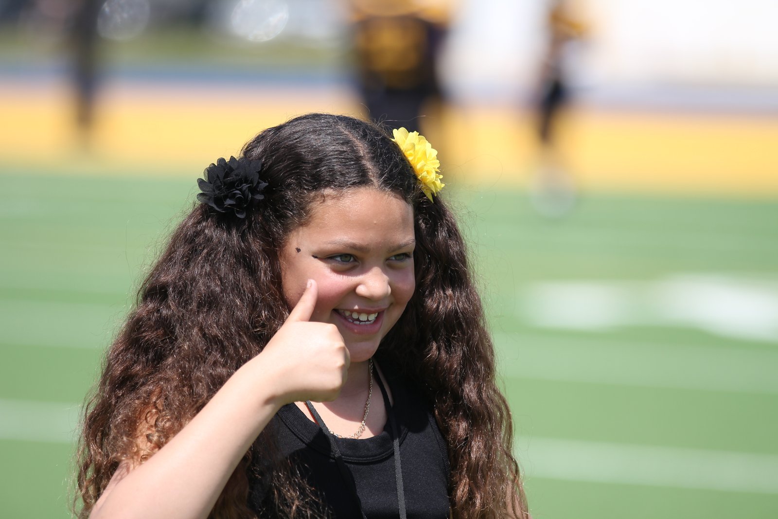 A young Bulldogs supporter on the sideline wearing two flowers in her hair, one black and one gold &mdash; the team's colors
